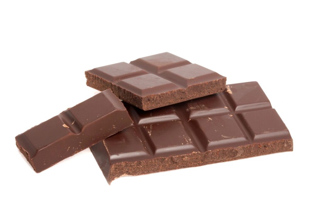 Bars of dark chocolate on white background